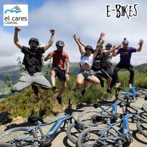 a group of people jumping in the air next to bikes at Camping el Cares in Santa Maria de Valdeón