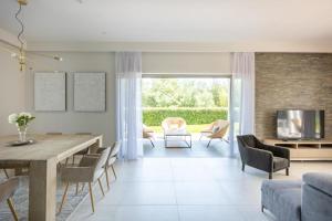 a living room with a table and chairs and a television at FRGK Luxury Two-Storey Villa with Pool & Rooftop Peaceful Setting Lord Brougham in Cannes