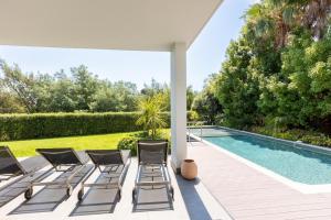 a group of chairs sitting next to a swimming pool at FRGK Luxury Two-Storey Villa with Pool & Rooftop Peaceful Setting Lord Brougham in Cannes