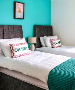 two beds in a room with blue walls at The Suite at O'Shea's in Killorglin