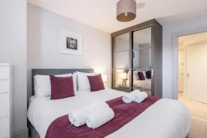a bedroom with a large white bed with towels on it at Roomspace Serviced Apartments - The Quadrant in Richmond upon Thames