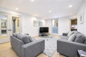 a living room with two couches and a flat screen tv at Roomspace Serviced Apartments - The Quadrant in Richmond upon Thames