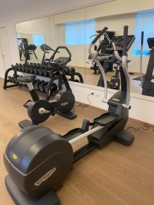 a gym with several cardio machines in a room at Open Space - Garden & Jacuzzi in Milan