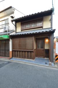 um edifício com portas de madeira numa rua em Takeya Gojo em Quioto