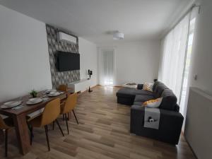 a living room with a couch and a table with chairs at Juniper 3 Business in Kecskemét