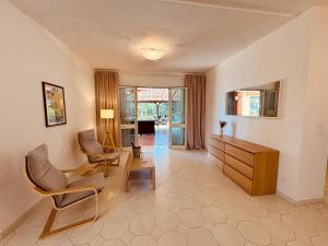 a living room with two chairs and a dresser at Villa mit großem Garten und Aufstellpool, 800m zum Meer, Lido Marini in Lido Marini