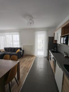 a kitchen and living room with a couch and a table at Juniper 3 Business in Kecskemét