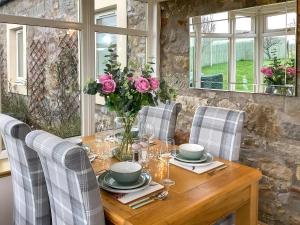 a wooden table with chairs and a vase of flowers at 2 Bed in Rosyth oc-r30512 in Rosyth