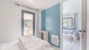 a bedroom with a bed and a dining room with a table at Camping de Saverne in Saverne +36 photos