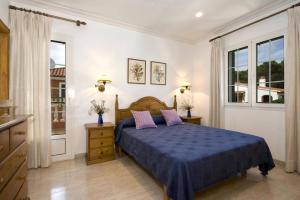 a bedroom with a blue bed and two windows at Villa Manuel by Villa Plus in Son Parc +20 photos