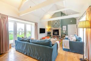a living room with two blue couches and a fireplace at 3 Bed in nr Beadnell oc-cr1279 in Beadnell