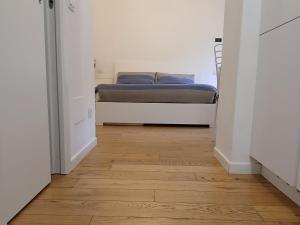 a bedroom with a bed and a wooden floor at Il monolocale in Bosisio Parini
