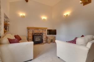 a living room with two chairs and a fireplace at 2 Bed in Settle oc-ds1038 in Settle