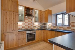 a kitchen with wooden cabinets and a stove top oven at 2 Bed in Settle oc-ds1038 in Settle