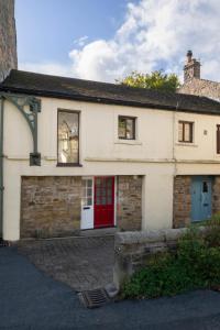 a white house with a red door and windows at 2 Bed in Settle oc-ds1038 in Settle