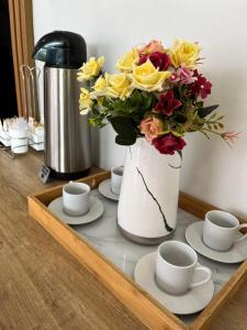 a tray with a vase with a bouquet of flowers at Hotel Seven in Goiânia