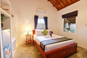 een slaapkamer met een bed, een dressoir en een raam bij An Bang Purple Homestay in Hội An +58 foto's