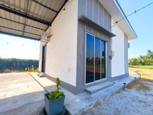 a house with a window and a potted plant at White House Villa in Sekinchan