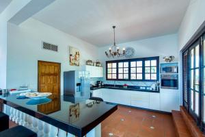 a large kitchen with a refrigerator and a counter at Villa Landhuis 6 - Coral Estate in Willibrordus
