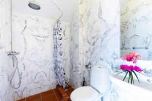 a white bathroom with a toilet and a bath tub at Villa Landhuis 6 - Coral Estate in Willibrordus +9 photos