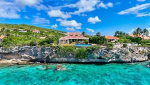 a house on a cliff next to the ocean at Villa Landhuis 6 - Coral Estate in Willibrordus