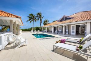 a house with a patio and a swimming pool at Villa Ocho 8 - Coral Estate in Willibrordus