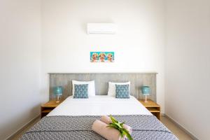 a bedroom with a white bed with blue pillows at Villa Ocho 8 - Coral Estate in Willibrordus +15 photos