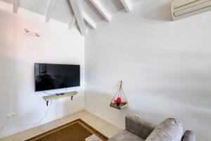a living room with a couch and a tv on a wall at Villa Ocho 8 - Coral Estate in Willibrordus