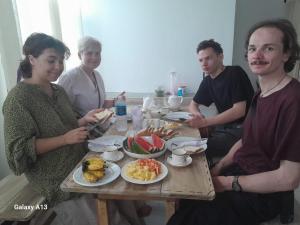 a group of people sitting around a table with food at Dad's Inn by Wee Group in Andiambalama