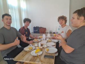 a group of people sitting around a table eating food at Dad's Inn by Wee Group in Andiambalama