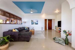 a living room with a couch and a blue ceiling at Scuba Dream Villa 519 - Coral Estate in Willibrordus
