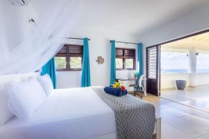 a bedroom with a white bed and a table at Scuba Dream Villa 519 - Coral Estate in Willibrordus +18 photos