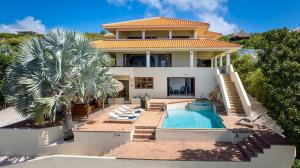 a house with a swimming pool in front of it at Scuba Dream Villa 519 - Coral Estate in Willibrordus