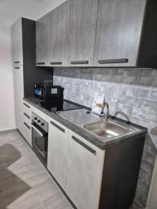 a kitchen with a sink and a microwave at Residenza Ohana in Isernia +5 photos