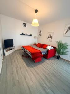 a bedroom with a bed and a couch and a television at Les Trois koush in Courcouronnes