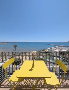 a yellow table and chairs on a balcony with the beach at TheSuperhost - Aquaria - Vista Mare in Crotone