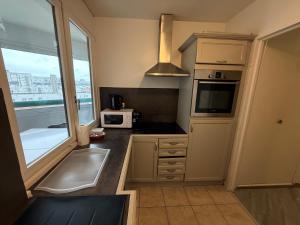 a kitchen with a sink and a microwave at Les Trois koush in Courcouronnes