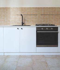 a kitchen with a stove and white cabinets at TheSuperhost - Aquaria - Vista Mare in Crotone +10 photos
