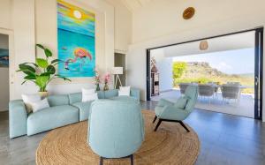 a living room with a blue couch and chairs at Villa Esmeraldas 1207 - Coral Estate in Willibrordus