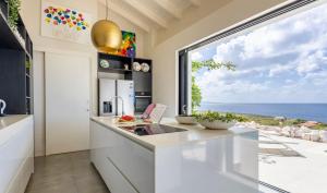 a kitchen with a view of the ocean at Villa Esmeraldas 1207 - Coral Estate in Willibrordus +10 photos