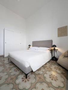 a bedroom with a large white bed and a carpet at TheSuperhost - Aquaria - Vista Mare in Crotone