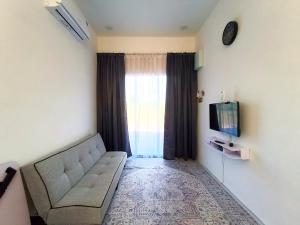 a living room with a couch and a tv at White House Villa in Sekinchan +16 photos