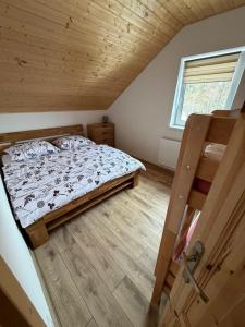 a bedroom with a bed and a wooden floor at Wellness chata Rybárie in Klokočov