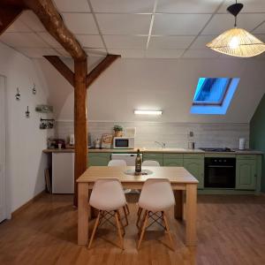 a kitchen with green cabinets and a table and chairs at Gite De La Baguelande in Les Andelys
