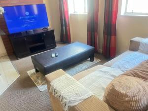 a living room with a flat screen tv and a couch at Peaceful stays in Mapungubwe in Johannesburg