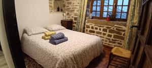 a bedroom with a bed with blue and yellow towels on it at La Grillère in Conliège