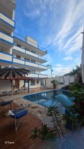 a hotel with a swimming pool in front of a building at Acapulco LUUM hotel in Acapulco