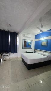 a bedroom with a large bed with a blue wall at Acapulco LUUM hotel in Acapulco