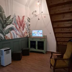 a living room with a tv on a wall at Gite De La Baguelande in Les Andelys