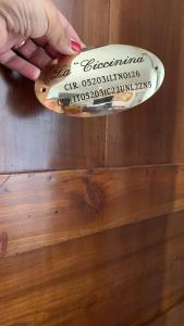 a hand holding a wooden spoon with a sign on it at la Ciccinina in Sarteano